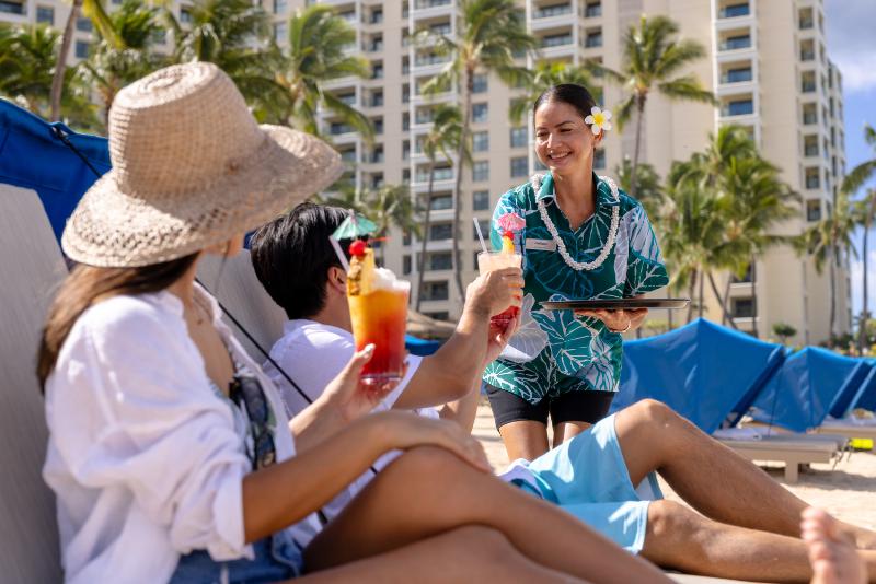 Vacatioing couple enjoying beachside drink service