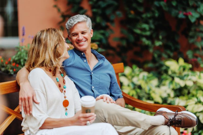Couple sharing coffee on scenic park bench
